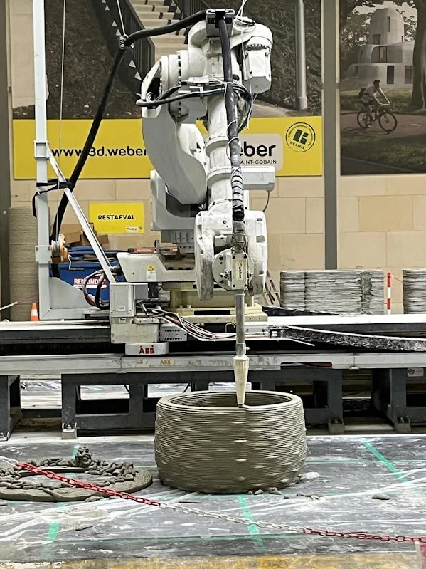 3d betonprinter in actie laag voor laag wordt de wand opgebouwd met een robotarm en mortelpomp