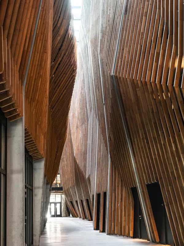 atrium van jonas gebouw met verticale houten lamellen en betonnen wanden