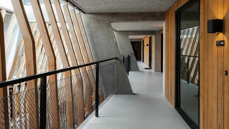binnengalerij jonas gebouw met natuurlijke daglichttoetreding en houten en betonnen afwerking
