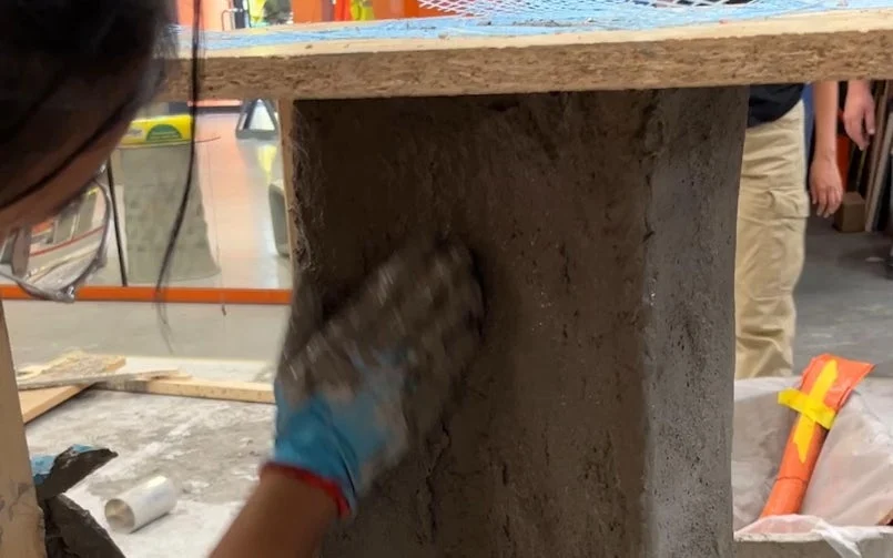 Het pleisteren van een textiel gaas met een stroperig betonmengsel (foto: Tektoniek)