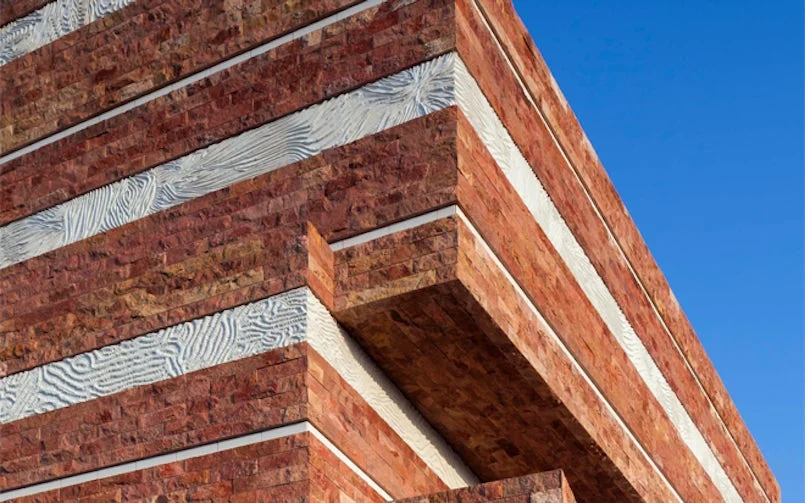 gevel natuursteen met witte betonpanelen
