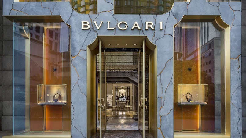 hoofdentree van de bulgari winkel met kenmerkende gevel van beton en transparante kunsthars in goudaccenten