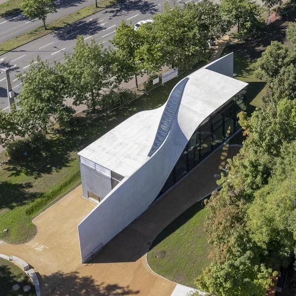 luchtfoto van henn cube paviljoen met golvende carbonbetonstructuur in park