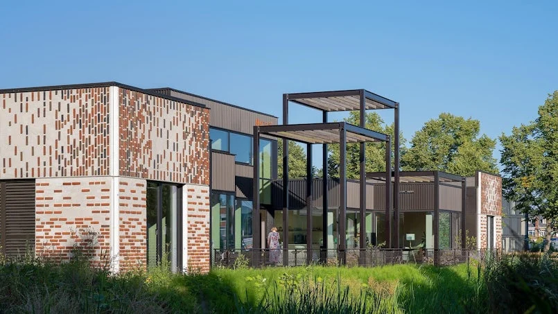 tuingevel maggies center met grote glaspartijen en beton