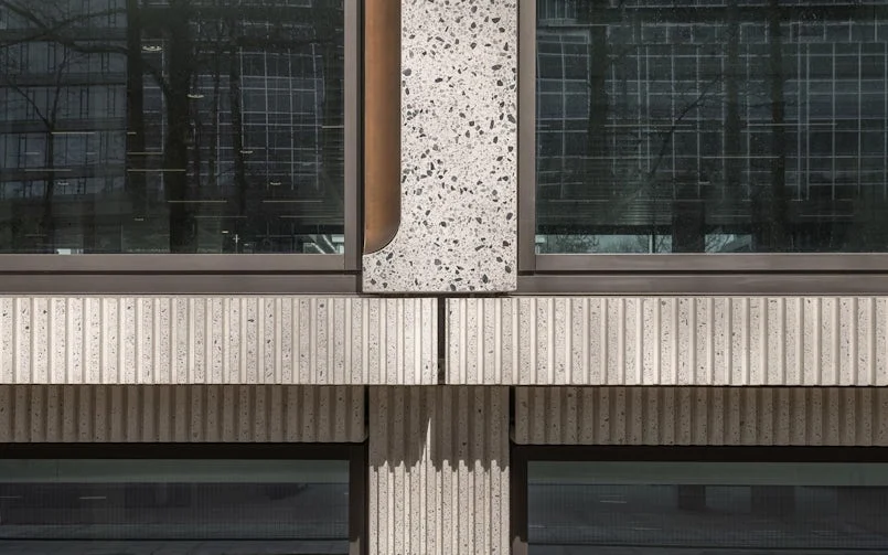 Het onderste gedeelte van de gevel zijn de kolommen en gevelbanden voorzien van cannelures als referentie naar de brutalistische, oude gevel (foto: Aiste Rakauskaite)