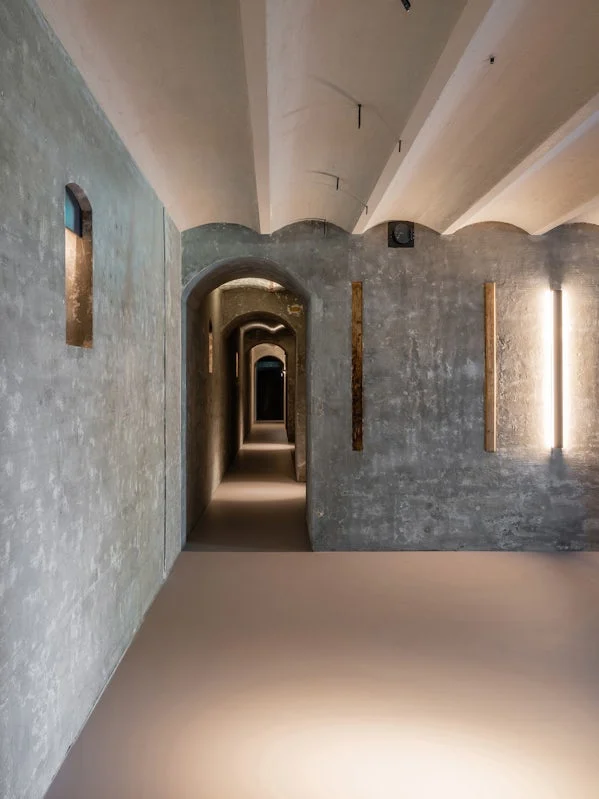 verlichte gang binnen het fort – historisch ritme en architectonisch lichtspel versterken beleving