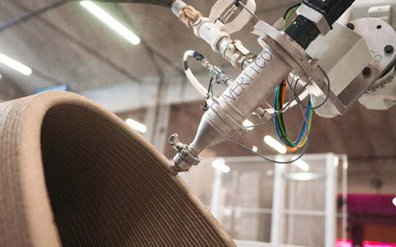 Een robotarm kan de printerkop in allerlei richtingen bewegen en kan zo ook op een schuin vlak printen. Vertico maakt gebruik van twee-componenten, waarbij een verharder in de printerkop bij de betonmortel wordt geïnjecteerd (foto: Vertico)