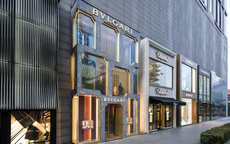 volledige straatgevel toont de harmonie tussen luxe retailarchitectuur en ambachtelijke betonbewerking