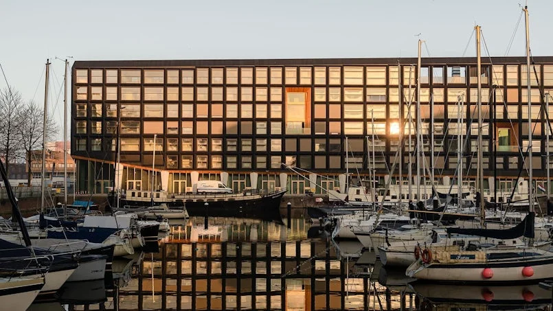 voorgevel jonas gebouw met duurzame betonnen structuur en ligplaatsen voor boten