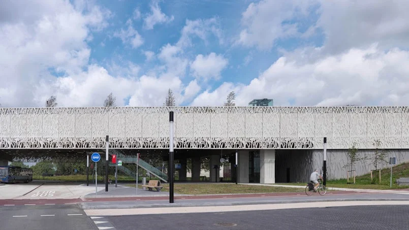 zijaanzicht van het gebouw waar de dunne betonnen randelementen als visuele bekroning fungeren